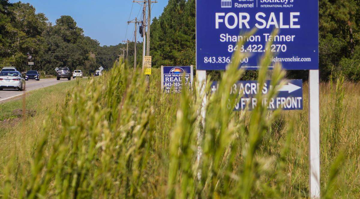 Signs boasting of land for sale, including property with waterfront access are posted as traffic moves along S.C. 462 at Bolan Hall Road on Friday, Oct. 14, 2022 in Jasper County.