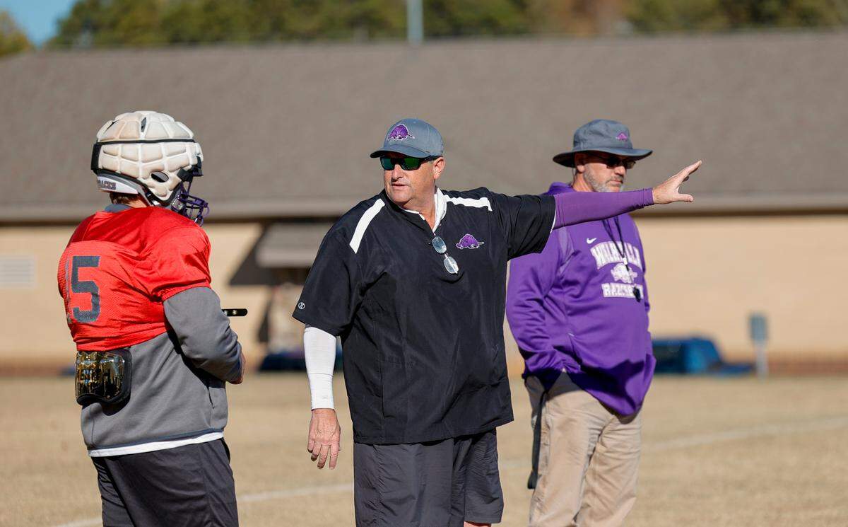 Walhalla football coach Padgett Johnson talks with quarterback Bryce Payne during practice at the school. Johnson has volunteered to coach the 3-A Razorback football team for the past seven seasons.