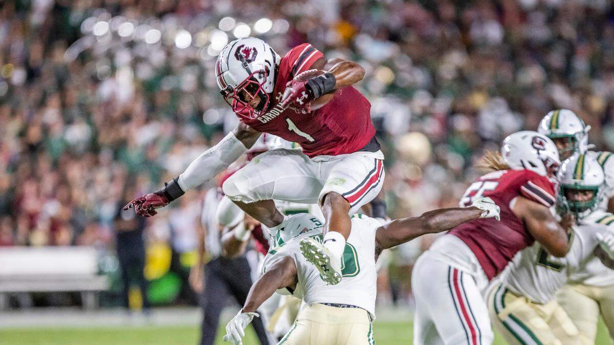 South Carolina running back MarShawn Lloyd (1) hurdles safety Wayne Jones of Charlotte during Saturday’s game at Williams-Brice Stadium.
