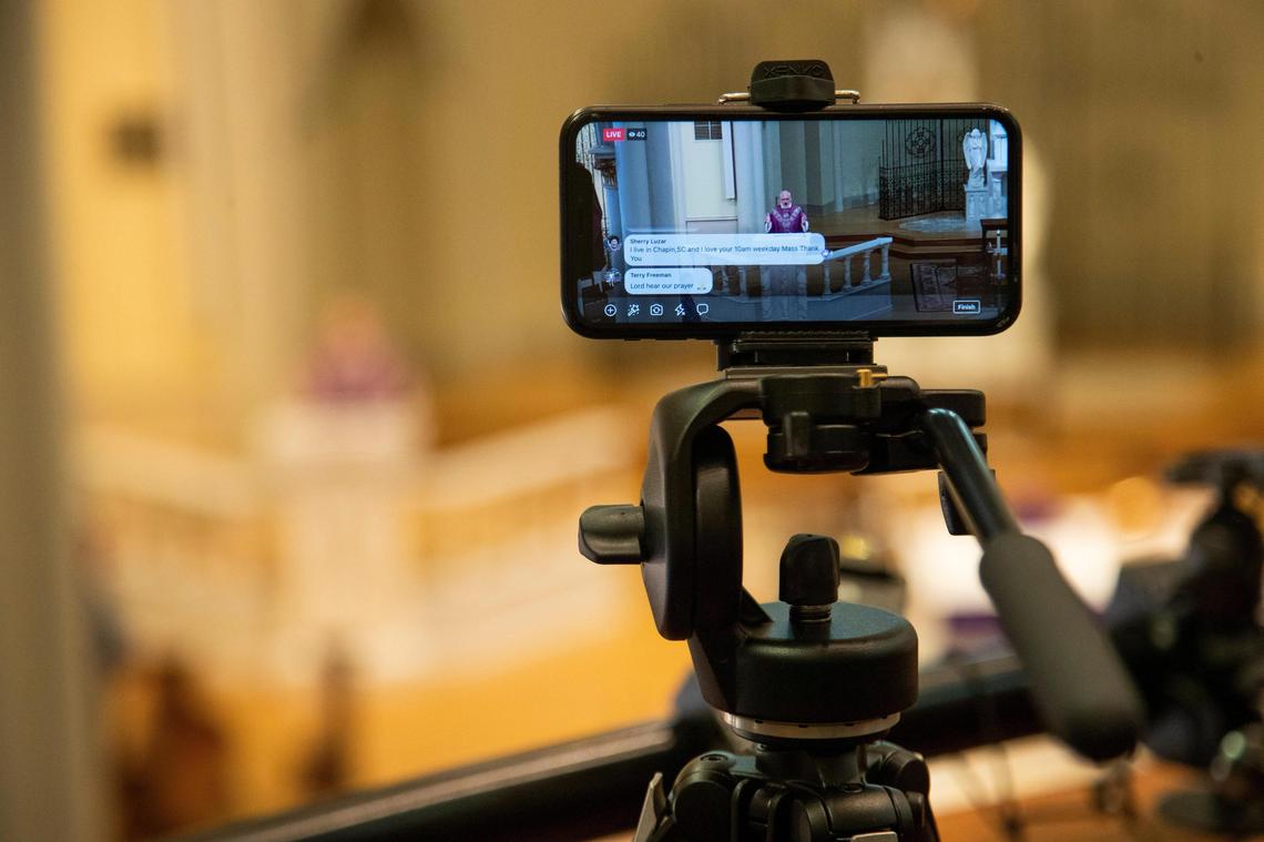 Father Gary Linsky is seen on a cellphone streaming to Facebook Live at St. Peter’s Basilica in downtown Columbia, South Carolina on Thursday, April 2, 2020. Since the Catholic Church has began social distancing measures, St. Peters has had to learn on the fly how to stream services onto the internet.