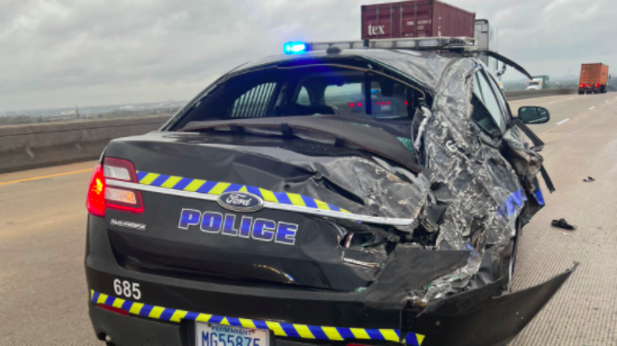 A Charleston police car was smashed by a shipping contain that wind blew off a truck, police said.