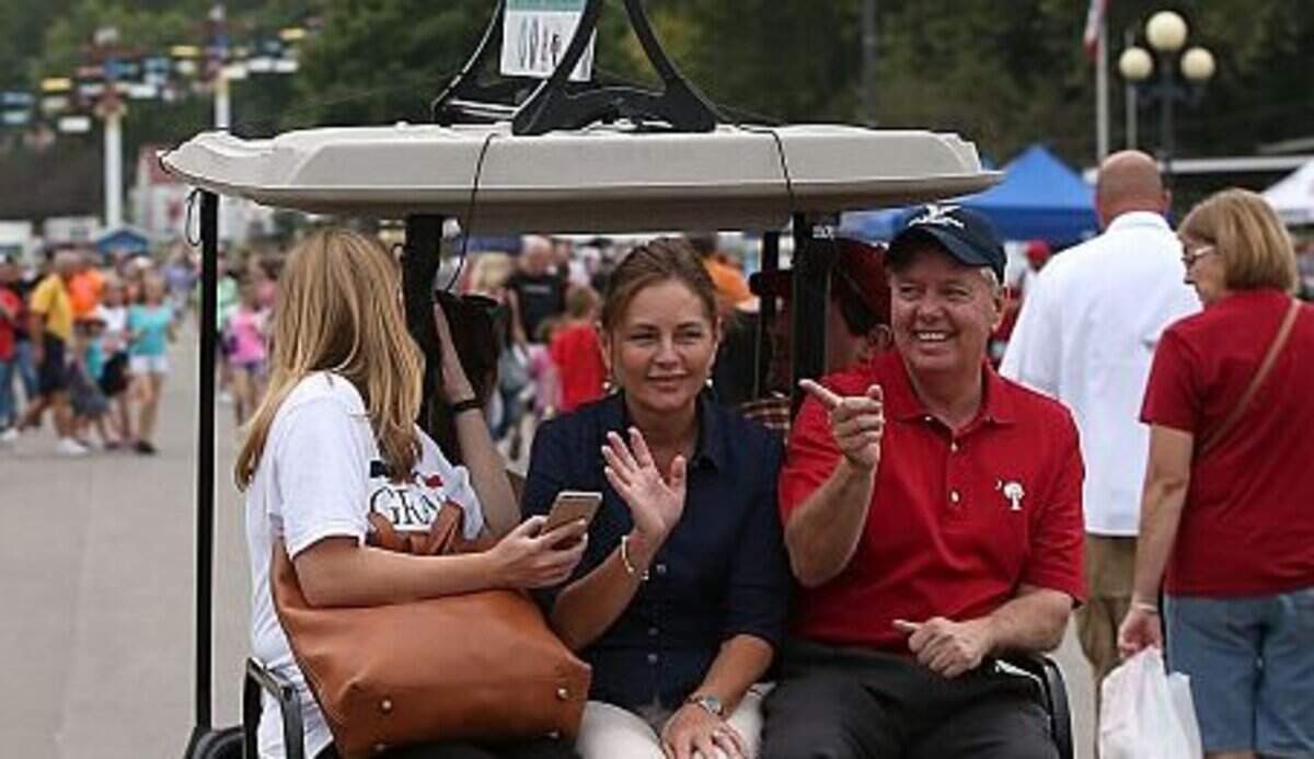 DES MOINES, IA - AUGUST 17: Republican presidential candidate and U.S. Sen. Lindsey Graham (R-SC) (R) (R-SC) rides on the back of a golf cart with his sister Darline Graham Nordone (C) during the Iowa State Fair on August 17, 2015 in Des Moines, Iowa. Presidential candidates are addressing attendees at the Iowa State Fair on the Des Moines Register Presidential Soapbox stage and touring the fairgrounds. The State Fair runs through August 23. (Photo by Justin Sullivan/Getty Images)