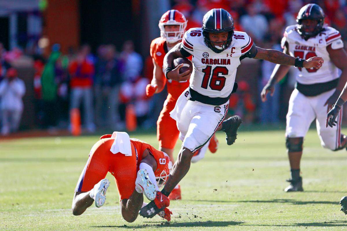University of South Carolina quarterback LaNorris Sellers (16) avoids being tackled by Clemson cornerback Tavoy Feagin (6) on Saturday, November 30, 2024. 
