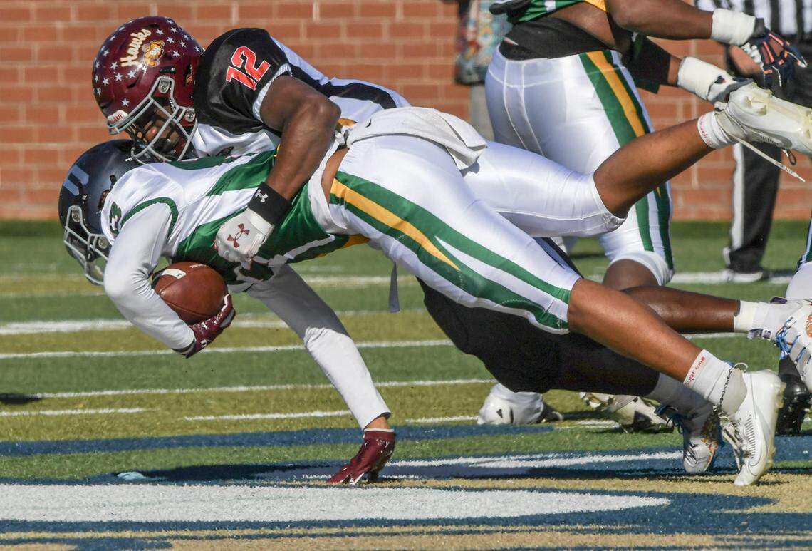 South team athlete JacQuel Holman (12) of Blackville-Hilda tackles North team running back Corey Blair (33) of East Forsyth High during the first quarter of the 2024 Shrine Bowl of the Carolinas at Viking Stadium in Spartanburg, S.C. Saturday, December 21, 2024.