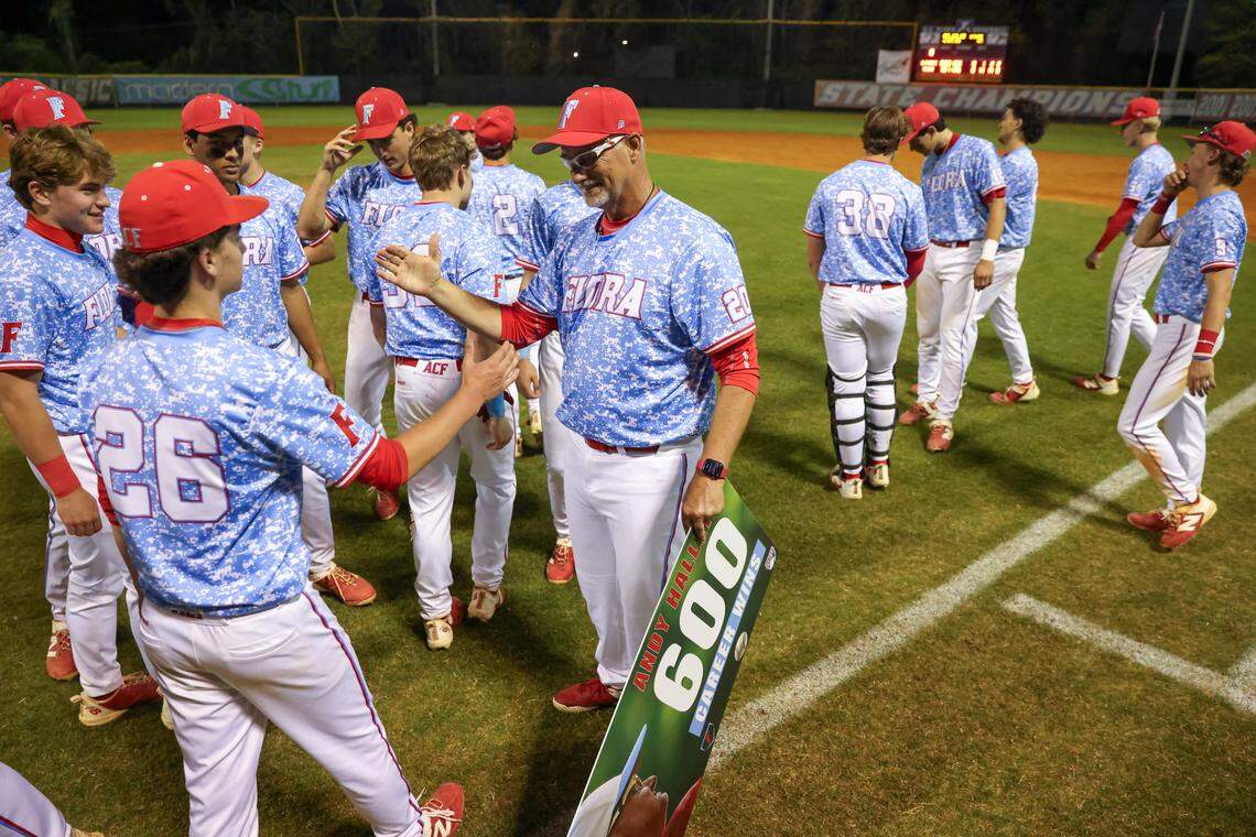 AC Flora head coach Andy Hallett is congratulated by Hank Gainous (26) after Hallett’s 600th win following their game against South Pointe in Columbia on Tuesday, March 31, 2026.