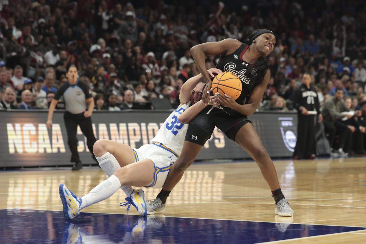 South Carolina's Raven Johnson (25) grapples with UCLA’s Angela Dugalić (32) for loose ball during the first half of action of their women's basketball game for the NCAA national championship against UCLA at Mortgage Matchup Center in Phoenix on Sunday, April 5,2026.