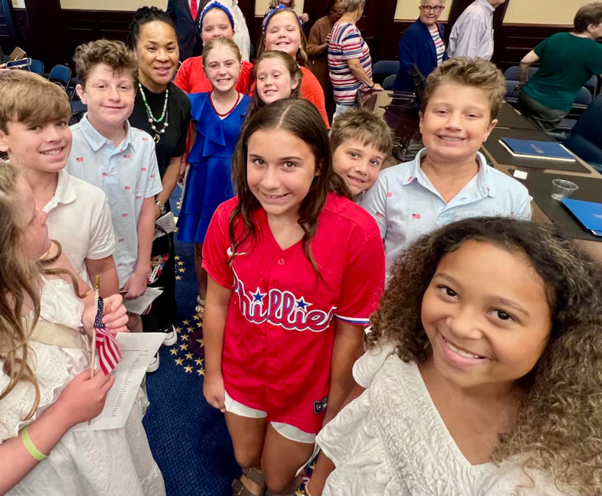 USC women’s basketball coach Dawn Staley with the Irmo Elementary School children’s choir, who sang “My Country ‘tis of Thee” at a packed naturalization ceremony Thursday.