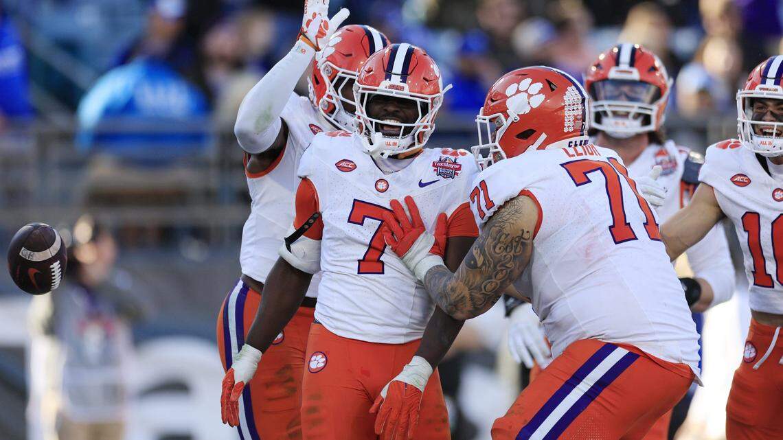 Clemson Tigers running back Phil Mafah (7) is congratulated by wide receiver Adam Randall (8), back, and Clemson Tigers offensive lineman Tristan Leigh (71) after scoring a touchdown during the fourth quarter of an NCAA football matchup in the TaxSlayer Gator Bowl Friday, Dec. 29, 2023 at EverBank Stadium in Jacksonville, Fla. The Clemson Tigers edged the Kentucky Wildcats 38-35.