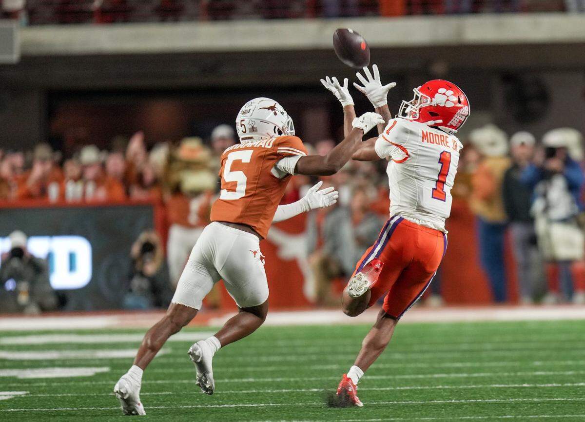 Clemson Tigers wide receiver T.J. Moore (1) catches the ball for a first down against Texas Longhorns defensive back Malik Muhammad (5) in the second half of an NCAA College Football Playoffs first round game at Darrell K Royal Texas Memorial Stadium, Austin, Texas, Saturday, Dec. 21, 2024.