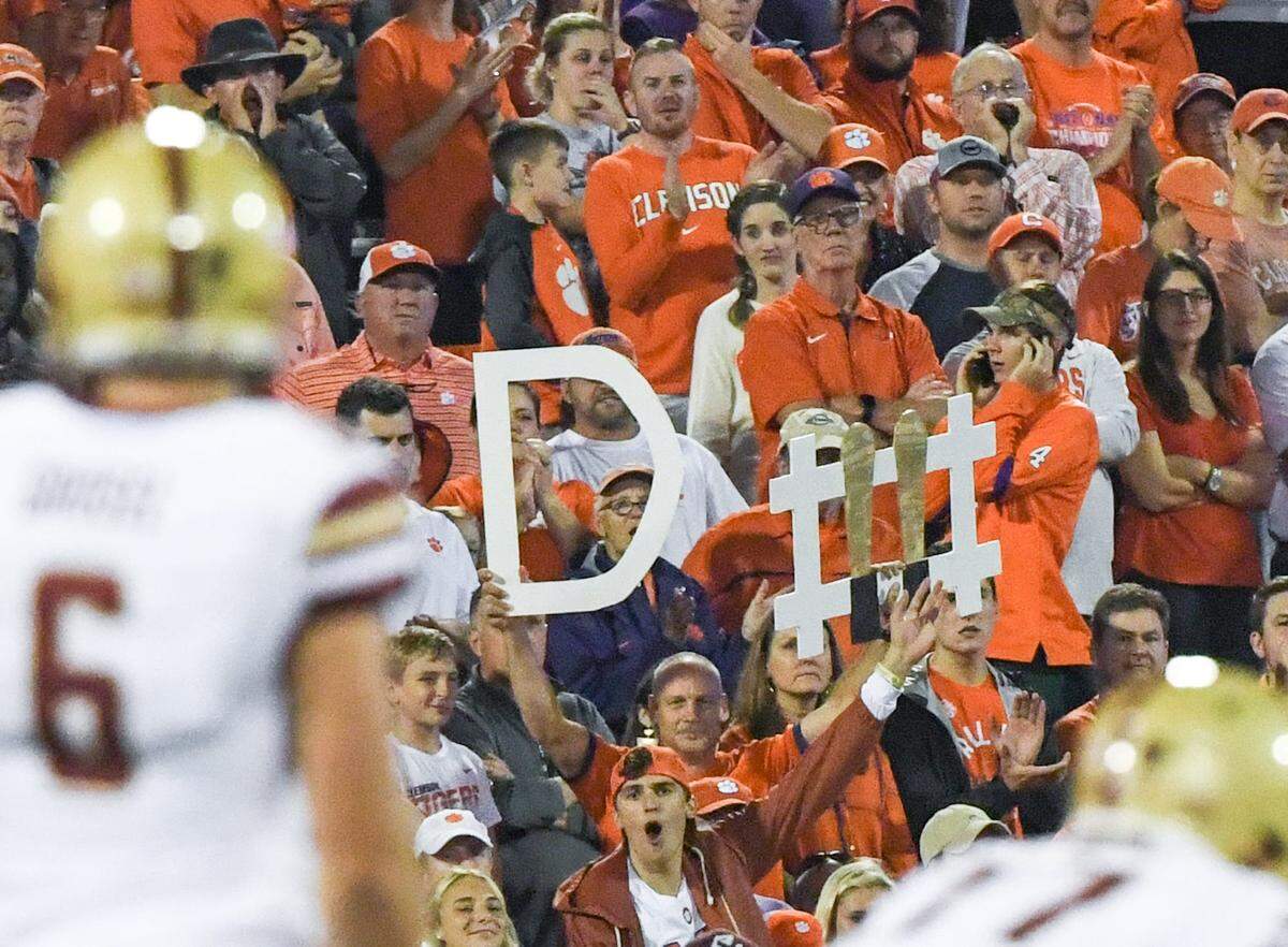 Clemson fan Tim Cowan, pictured here in a 2019 game against Boston College, frequently pops up on TV broadcasts for the defense signs he holds up midgame from a seat right above the visitors sideline at Memorial Stadium.