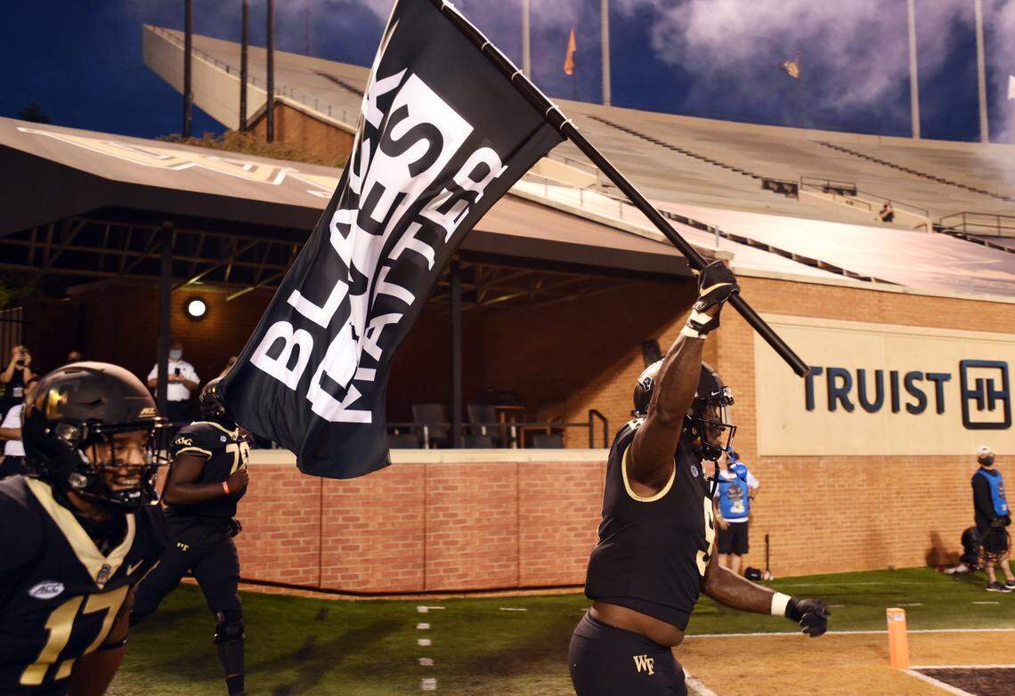 Promoting social justice was on the minds of Clemson and Wake Forest players. Both teams wore various helmet stickers to show support. The Clemson football team’s helmet stickers included the phrases “Black lives matter,” “equality,” “love” and “put a stop to racism.” Here, Wake Forest defensive end Carlos “Boogie” Basham carries a Black Lives Matter flag on to the field before the game.