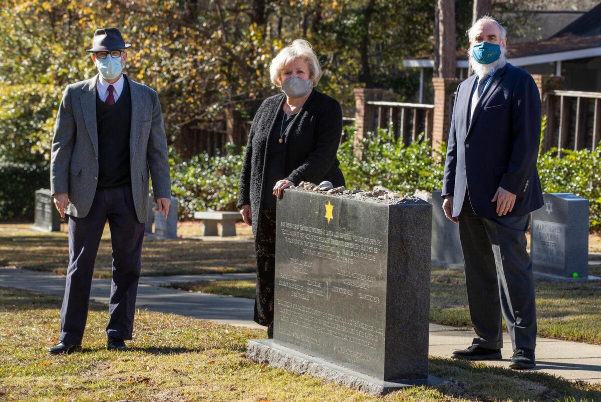 Rabbi Jonathan Case, Dr. Lilly Filler and Rabbi Hesh Epstein stand near a memorial for victims of the Holocaust and Filler’s family who survived the Holocaust at Beth Shalom Cemetery on Thursday, December 10, 2020. Recently ashes of a victim of the Dachau concentration camp in Germany were interned in front of the gravestone.