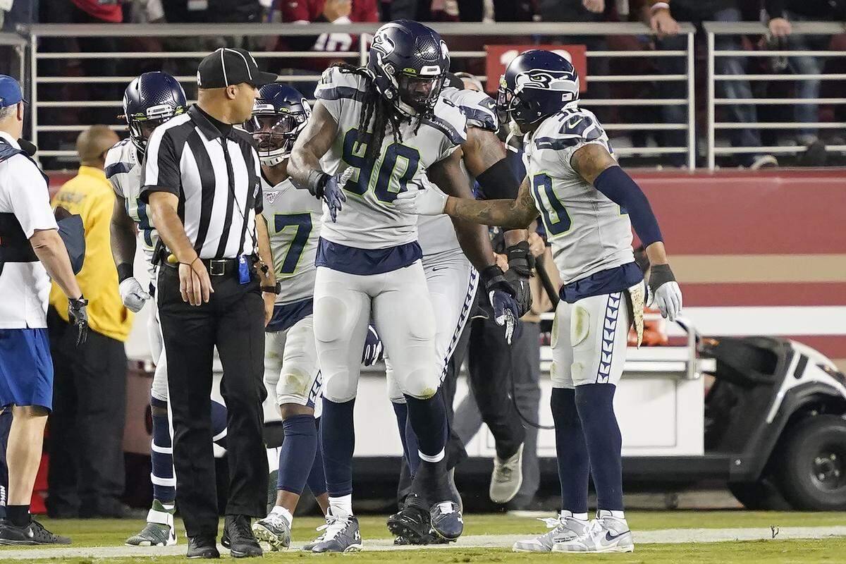 Seattle Seahawks defensive end Jadeveon Clowney (90) is congratulated by strong safety Bradley McDougald (30) after scoring against the San Francisco 49ers during the first half of an NFL football game in Santa Clara, Calif., Monday, Nov. 11, 2019.