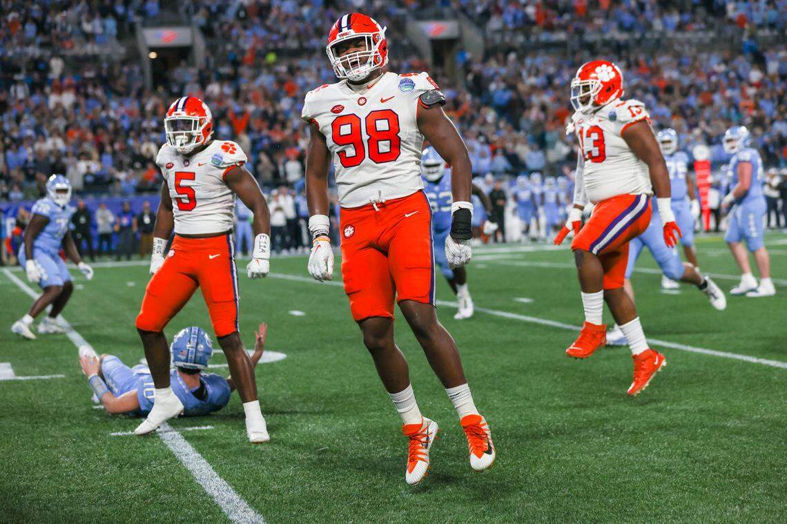 Clemson Tigers defensive ends K.J. Henry (5), and Myles Murphy (98) and defensive tackle Tyler Davis celebrate against the North Carolina Tar Heels at the 2022 ACC Championship in Charlotte, N.C., Saturday, Dec. 3, 2022. (Photo by Taylor Banner/ACC)