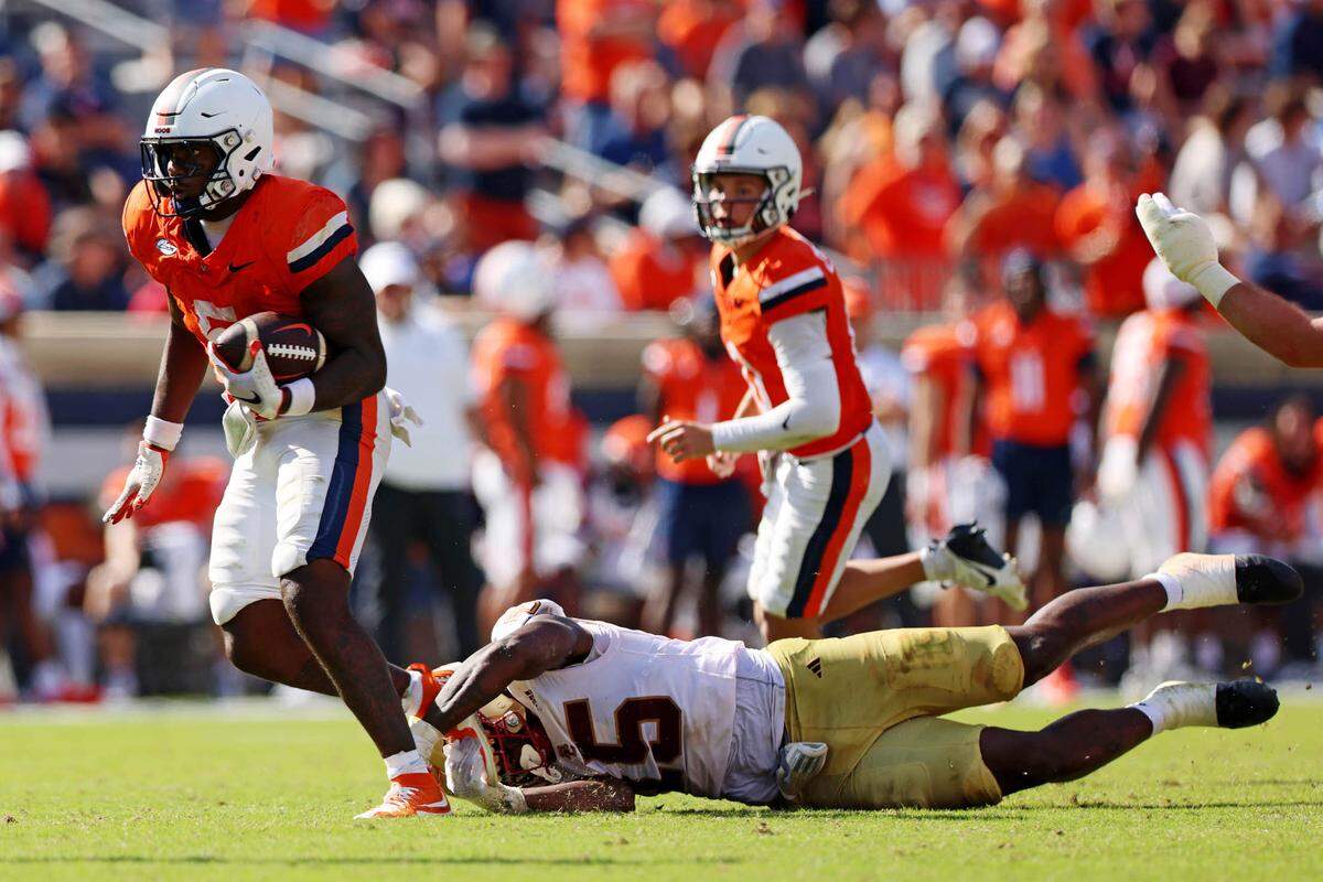 Oct 5, 2024; Charlottesville, Virginia, USA; Virginia Cavaliers running back Kobe Pace (5) runs the ball against Boston College Eagles defensive end Quintayvious Hutchins (15) during the fourth quarter at Scott Stadium.