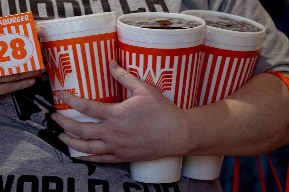 A woman stands with an armload of drinks during the grand opening of the Whataburger in Irmo on Monday, Sept. 9, 2024.