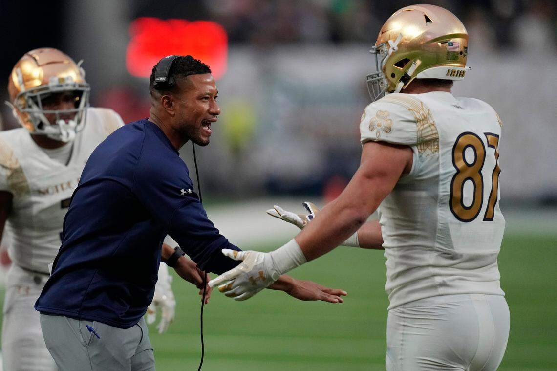 Notre Dame head coach Marcus Freeman, left, celebrates after Notre Dame tight end Michael Mayer (87) made a touchdown catch against BYU during the first half of an NCAA college football game Saturday, Oct. 8, 2022, in Las Vegas. (AP Photo/John Locher)