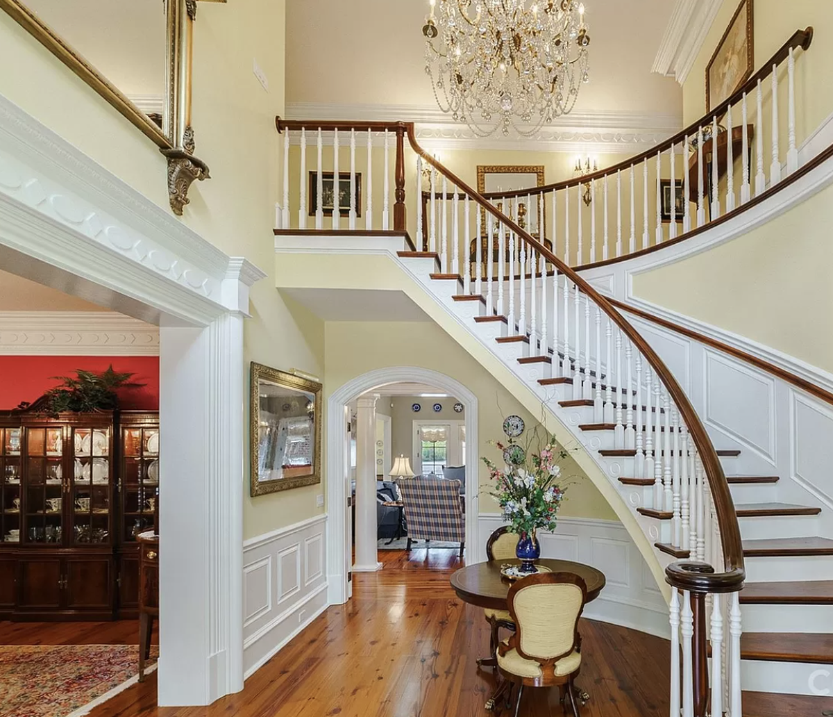 An antique chandelier is at the top of the staircase.