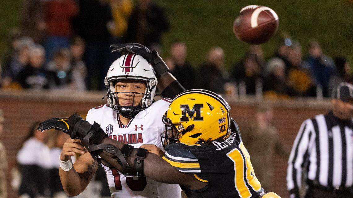 Missouri defensive lineman Trajan Jeffcoat, right, hits South Carolina quarterback Jason Brown, left, as he throws during the third quarter of an NCAA college football game Saturday, Nov. 13, 2021, in Columbia, Mo. Missouri won 31-28. (AP Photo/L.G. Patterson)