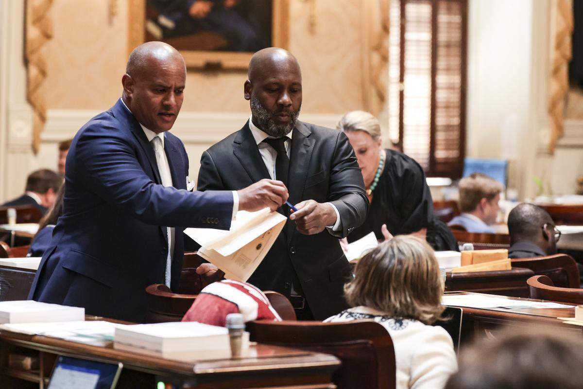 State Reps. Todd Rutherford, D-Richland and Chris Hart, D-Richland, work in the house chamber on Tuesday, April 14, 2026.