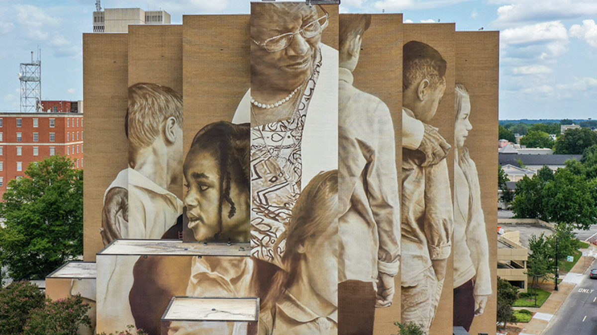 A mural on the side of an eight-story building at one entrance the downtown Greenville honors Pearlie Harris, a pioneer in education.
