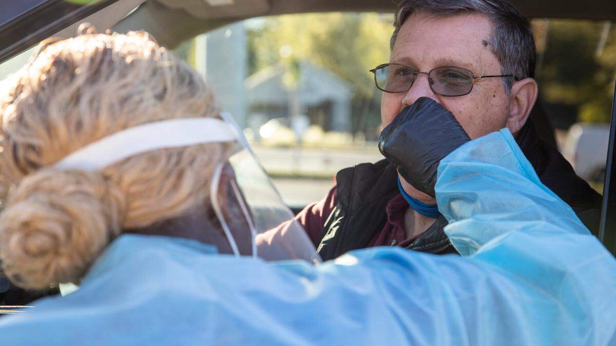 Douglass Bennick receives an oral coronavirus test from Erica Clay in Columbia, South Carolina on Tuesday, November 17, 2020. The South Carolina Department of Health and Environmental Control parking lot on Bull Street offers free coronavirus tests. People can register for a test at gogettested.com.