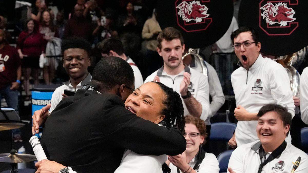 South Carolina women’s basketball coach Dawn Staley hugs USC band director Quintus Wrighten after the Gamecocks beat Duke in the Elite Eight at Legacy Arena in Birmingham, Alabama