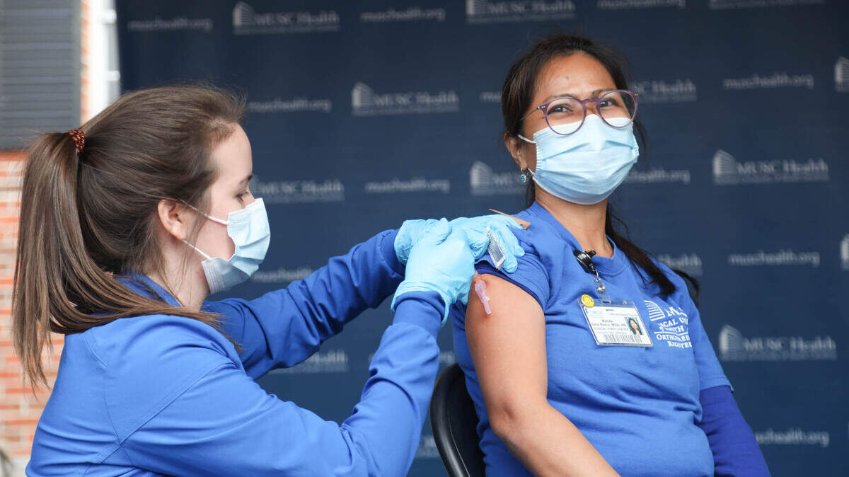 Registered nurse Erika Hutzler administers the Covid-19 vaccine to Metzfe Dela Rama at The Medical University of South Carolina in Charleston, S.C. on Tuesday, Dec. 15, 2020.