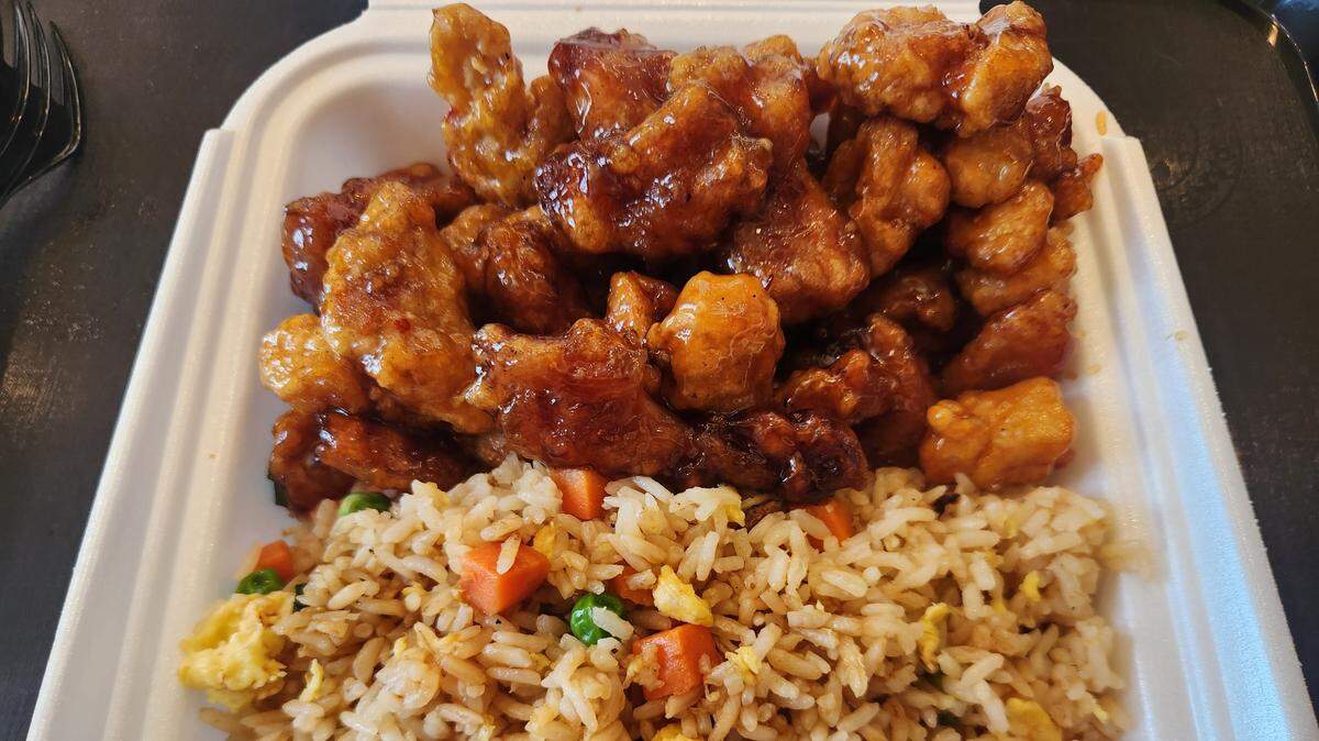 A plate of orange chicken and fried rice at a Panda Express location.