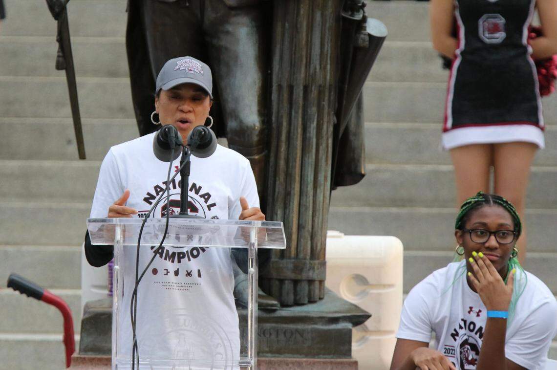University of South Carolina women’s basketball head coach Dawn Staley speaks to a crowd of supporters on Wednesday, April 13, 2022, in Columbia, S.C., as player Aliyah Boston watches on.