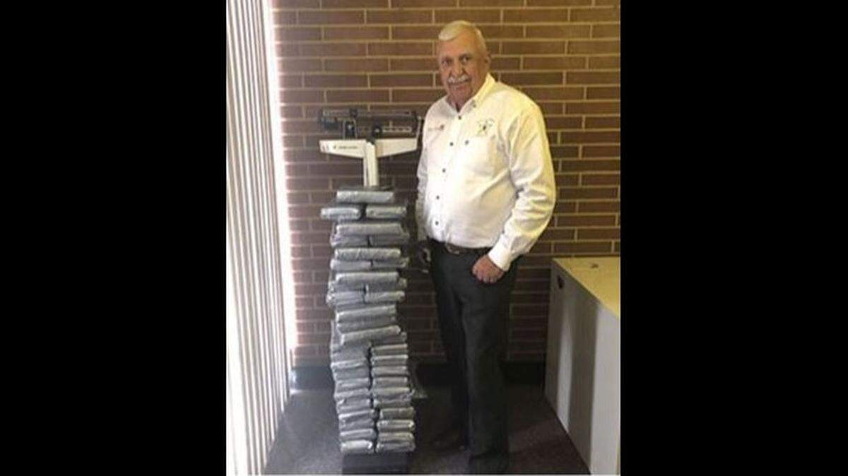 Lincoln County Sheriff Bill Beam stands next to more than 100 pounds of cocaine that was seized in a traffic stop.