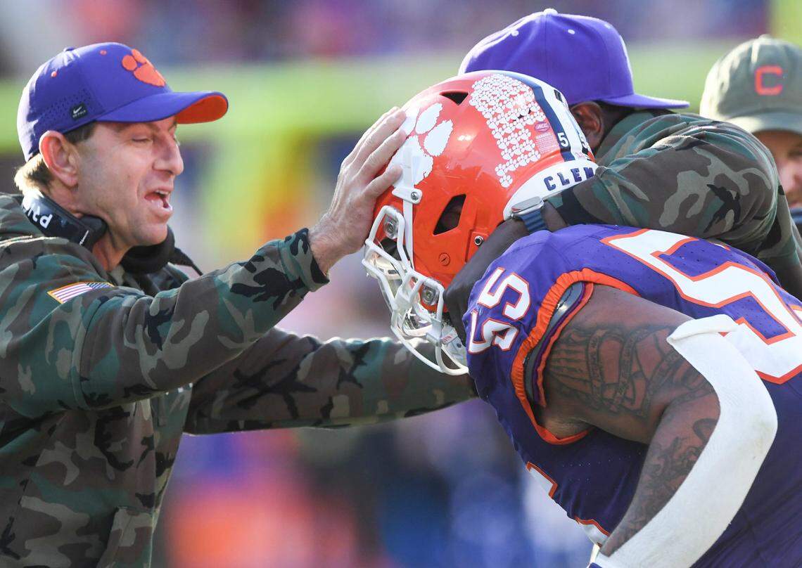 Nov 23, 2024; Clemson, South Carolina, USA; Clemson Tigers head coach Dabo Swinney and defensive tackles coordinator Nick Eason hug defensive tackle Payton Page (55) after Page returned an interception for a touchdown during the first quarter against The Citadel Bulldogs at Memorial Stadium.