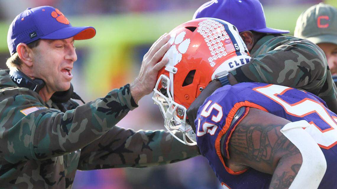 Nov 23, 2024; Clemson, South Carolina, USA; Clemson Tigers head coach Dabo Swinney and defensive tackles coordinator Nick Eason hug defensive tackle Payton Page (55) after Page returned an interception for a touchdown during the first quarter against The Citadel Bulldogs at Memorial Stadium.