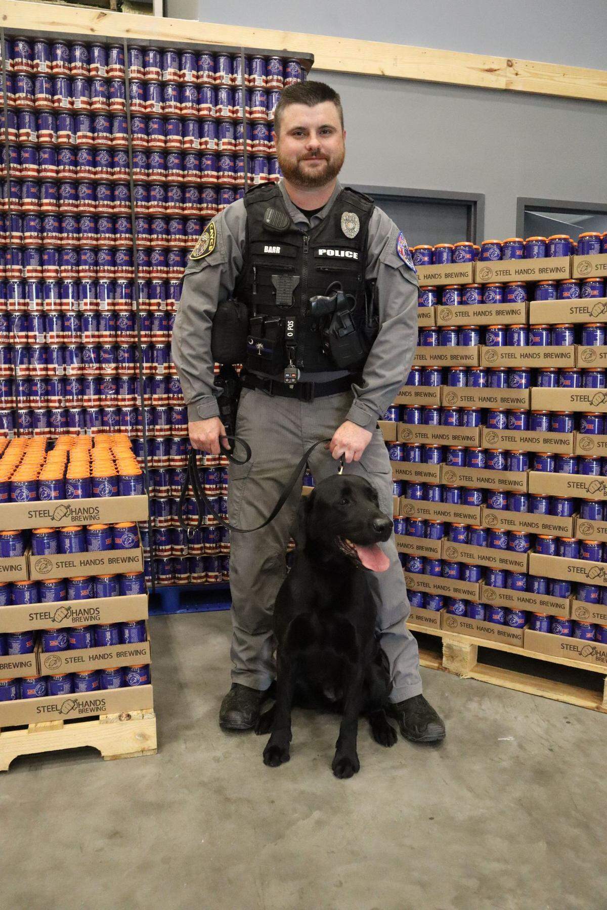 Cayce Police Officer Drew Barr and his K9 Molly pose with cases of the Steel Paws wheat ale from Cayce’s Steel Hands Brewing to promote the Steel Paws initiative. Barr was killed in a shooting early Sunday morning, April 24, 2022.