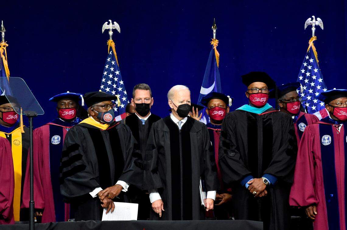 President Joe Biden, center, flanked by U.S. House Majority Whip Jim Clyburn, left, and Col. Alexander Conyers, the HBCU’s president, arrive at commencement exercises for South Carolina State University Friday, Dec. 17, 2021, in Orangeburg, S.C. (AP Photo/Meg Kinnard)