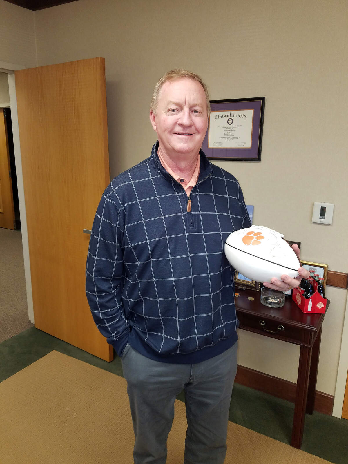 Among the prized possessions in Bob Paulling’s office is a football helmet signed by both Danny Ford and Dabo Swinney