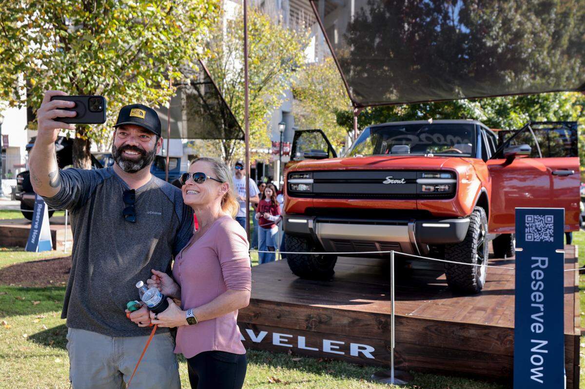 George Workman and Jessica Bayer make a photograph with the new Traveler SUV by Scout Motors. The concept cars were on display at Williams-Brice Stadium before USC’s game against Missouri on Saturday, Nov. 16, 2024.