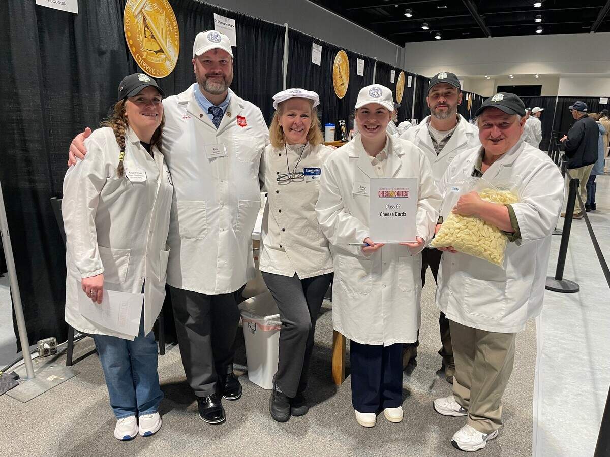 Clemson University graduate student Lucy Jeter (center, holding sign) is one of the country’s top collegiate dairy product judgers and got to shadow professional judges at the 2025 national contest after winning a college competition in 2024.