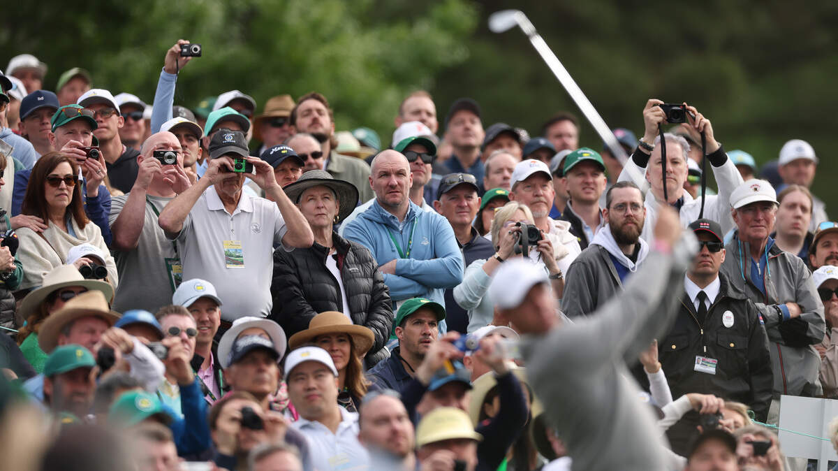 Patrons watch Rory McIlroy plays a shot from the 12th hole tee box during a practice round Tuesday prior to the 2026 Masters Tournament.