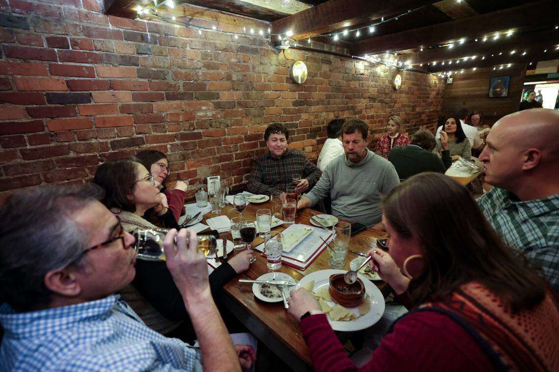 Patrons, including, from left, Edmundo Rodrigues, Elaine Bouse, Amy Allen, Todd Beasley, David Edge, Andy Boyd and Jennifer Boyd, enjoy dinner and drinks at Hunter Gatherer in Columbia on Thursday Dec. 12, 2024. Hunter Gatherer opened in 1995 as Columbia’s first microbrewery and will close at the end of December.