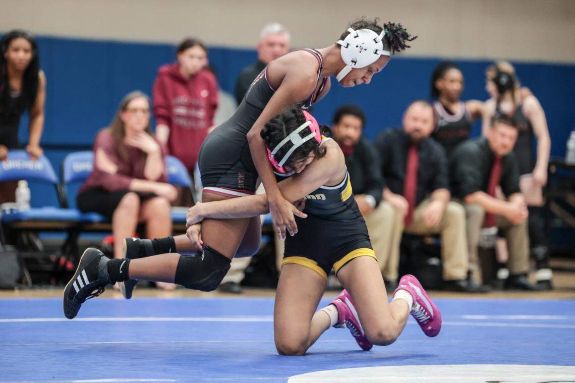 Greenwood’s Alanise Ricardo hoists Rock Hill’s Zoey McClurkin the Class 5A state championships at Dreher High School on Saturday, Feb. 8 2025.