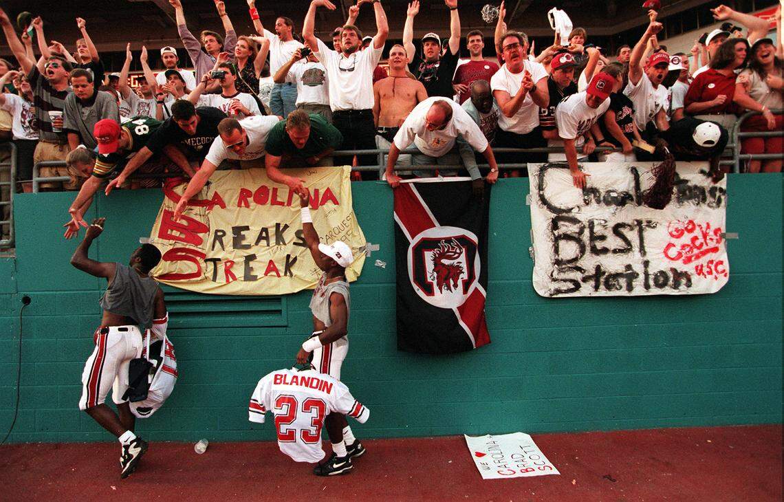Gamcock players Howard and Blandin celebrate with the crowd after their team won the Carquest Bowl at Joe Robbie Stadium. This was South Carolina’s first bowl victory.