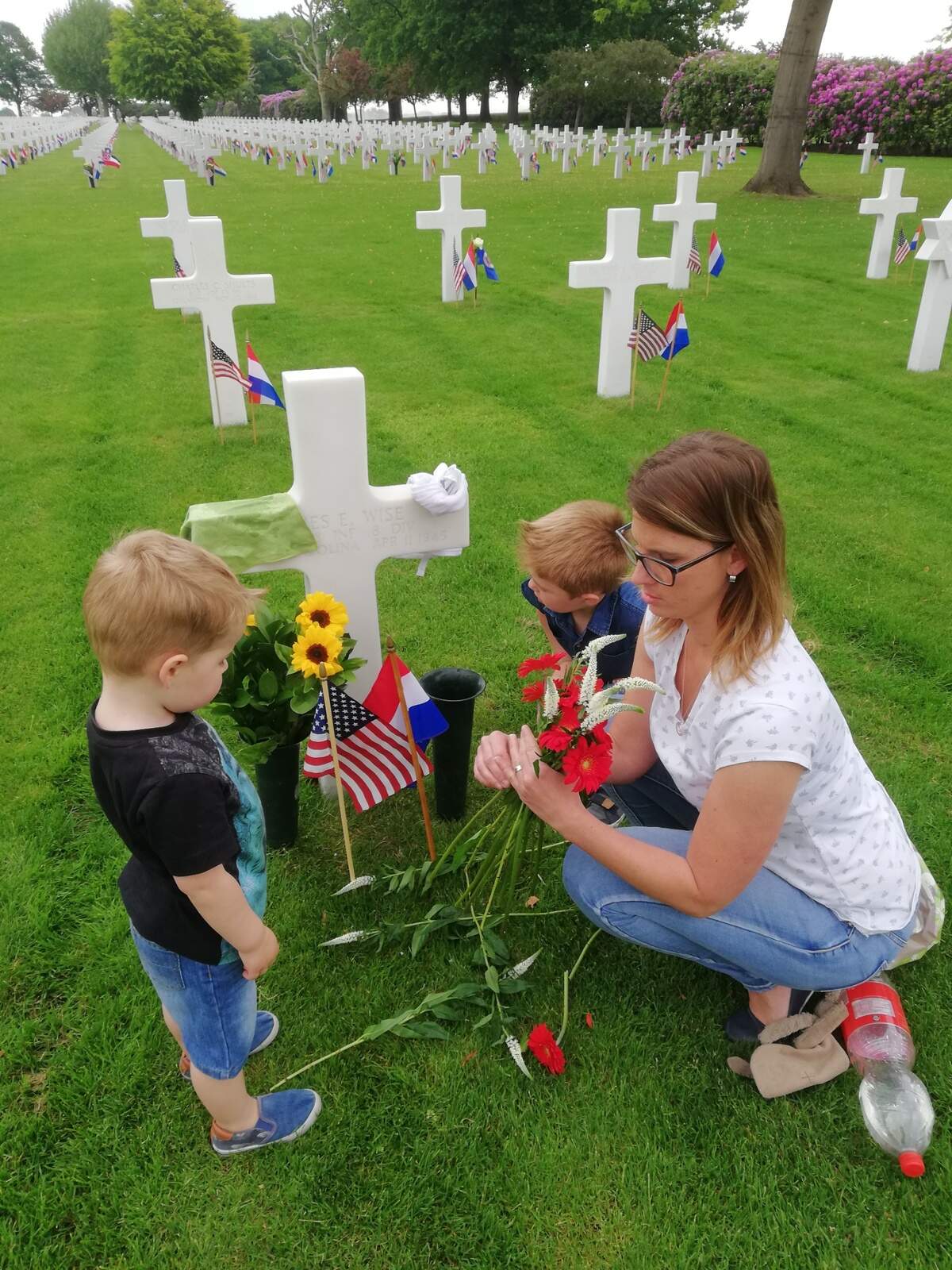 Brothers Wess and Lynn Warnier and their mother, Cindy, visit the grave of James E. Wise, a World War II soldier from Lake View, S.C., who they adopted at the Netherlands American Cemetery in Margraten.