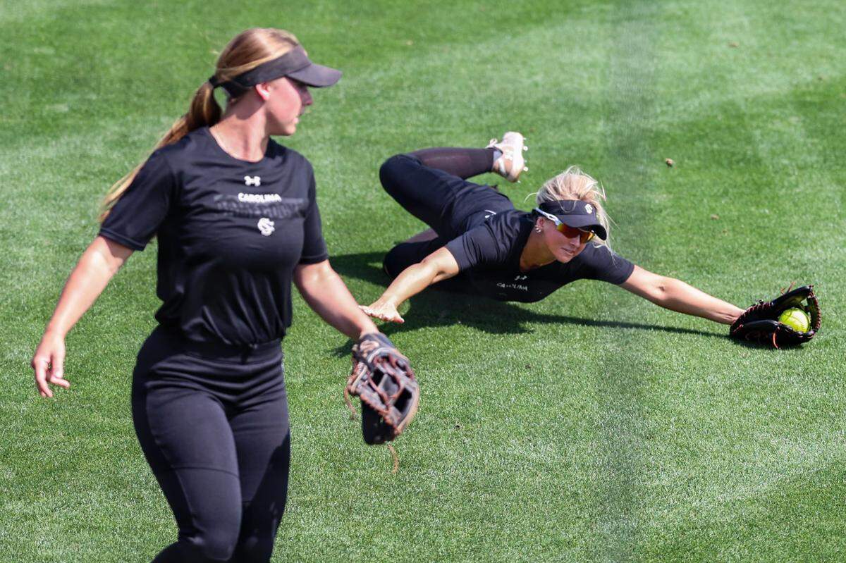 University of South Carolina’s Chloe Lackey (26) makes a diving catch as Karley Shelton (33) watches during practice at the Carolina Softball Stadium before the NCAA Columbia Regional on Thursday, May, 15, 2025.