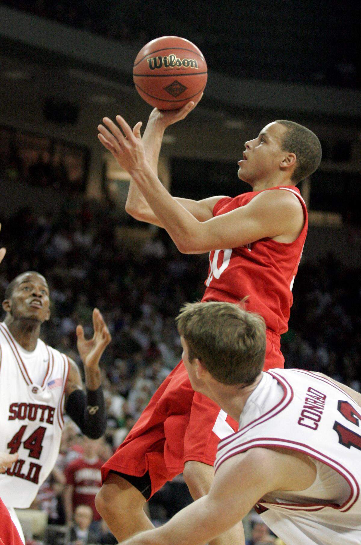Davidson guard Stephen Curry, center, drives past South Carolina guard Branden Conrad, during the second half of the NIT college basketball tournament game, Tuesday, March 17, 2009, in Columbia, S.C. (AP Photo/Brett Flashnick)