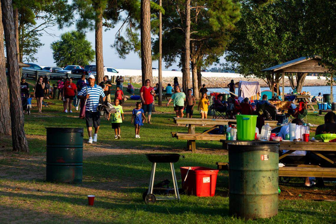 Families keep their distance from one another at the boat ramp and park near the Dreher Shoals Dam at Lake Murray on Saturday, July 4, 2020. While the park is open for people to view the Independence Day fireworks, bathrooms are still closed to help stop the spread of the coronavirus.
