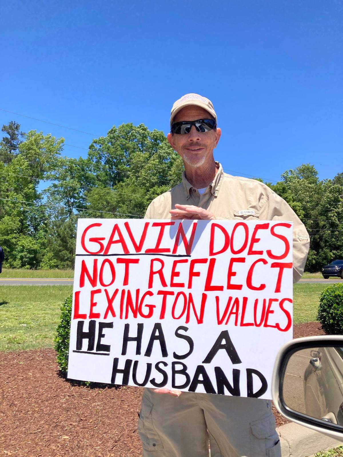 A protester holds a sign on election day in Lexington, SC, against the election of Gavin Smith to the town council.
