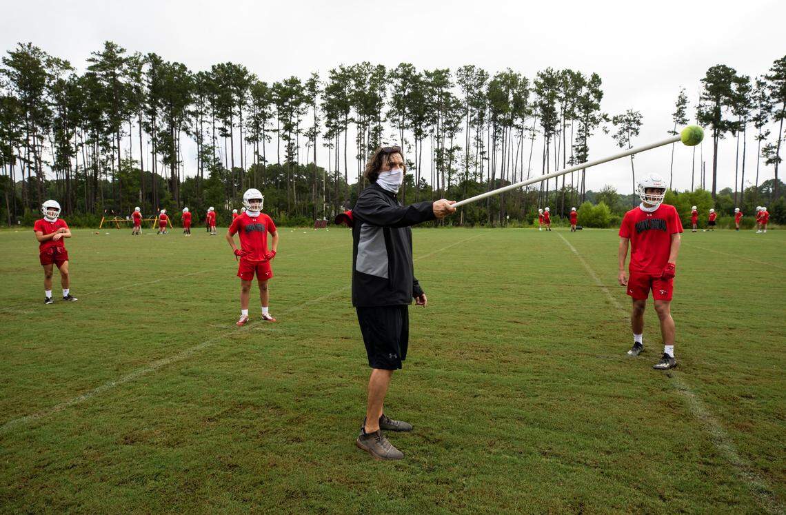 Head football coach Doug Dutton speaks with his players during practice at Cardinal Newman School on August 4, 2020.