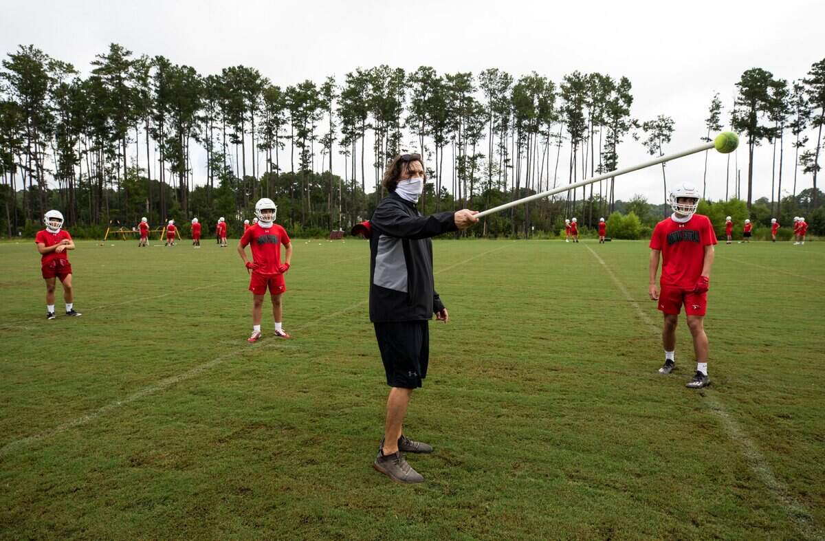 Head football coach Doug Dutton speaks with his players during practice at Cardinal Newman School on August 4, 2020.