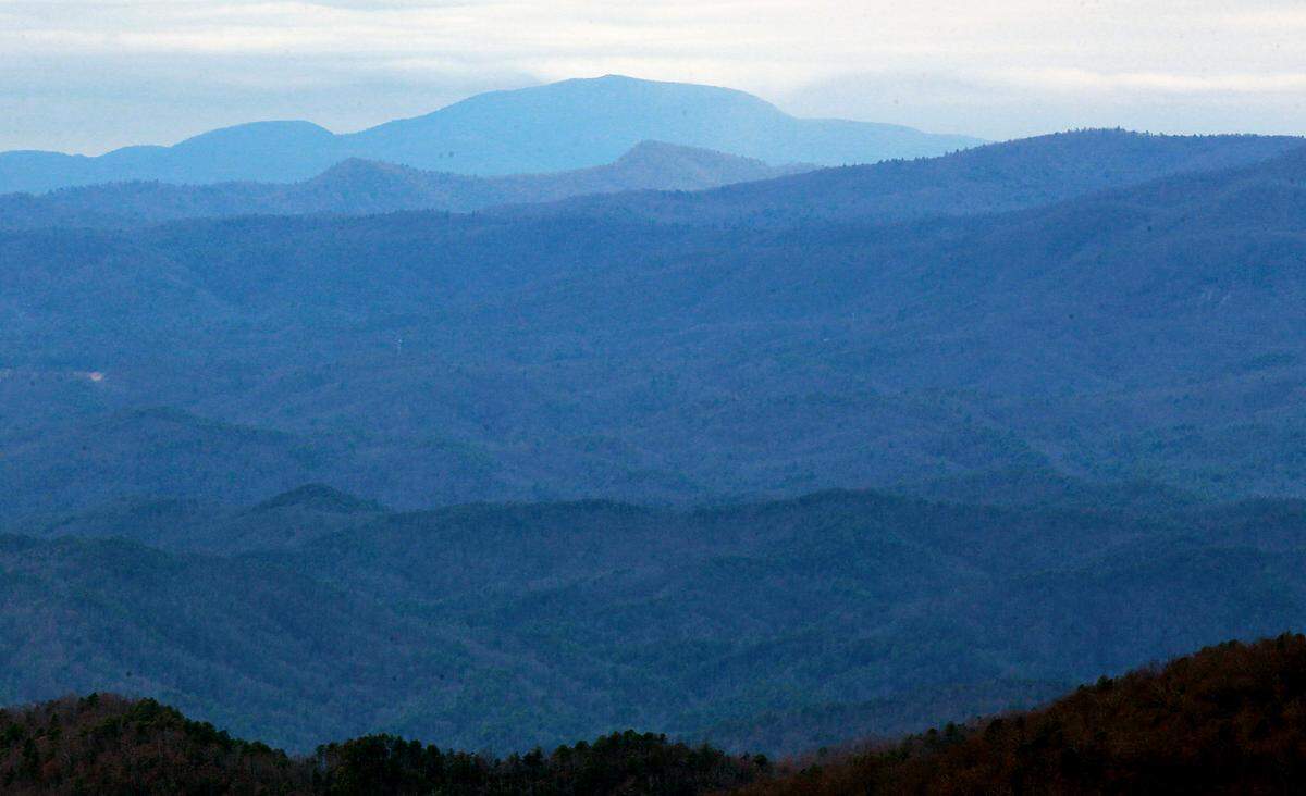 This view of the Blue Ridge Mountains is from SC's tallest peak, Sassafras Mountain. On a clear day viewers can see four states, SC, NC, GA, and TN. Naturalist Dennis Chastain is credited with helping raise awareness about protecting the Sassasfras peak from development. It was later protected by the state Department of Natural Resources.